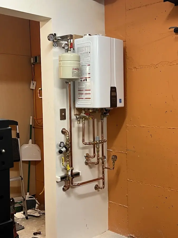 Plumbing technician inspecting water heater connections in Longbranch